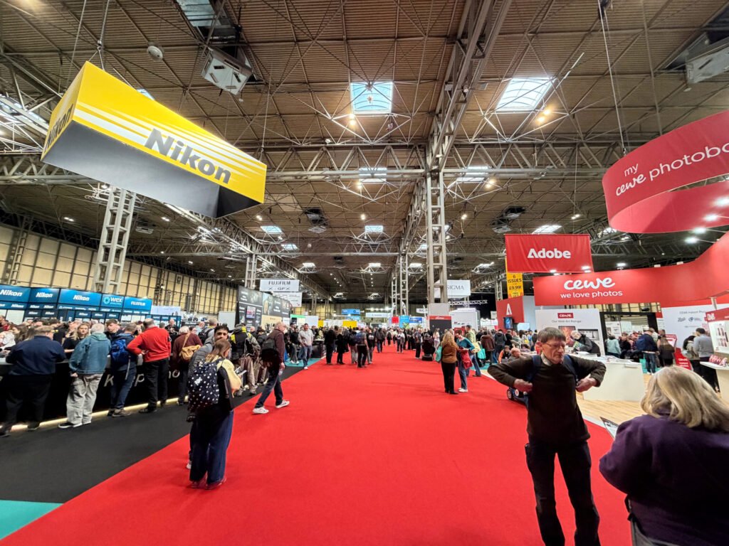 wide angle photo of people and stands at a photography exhibition