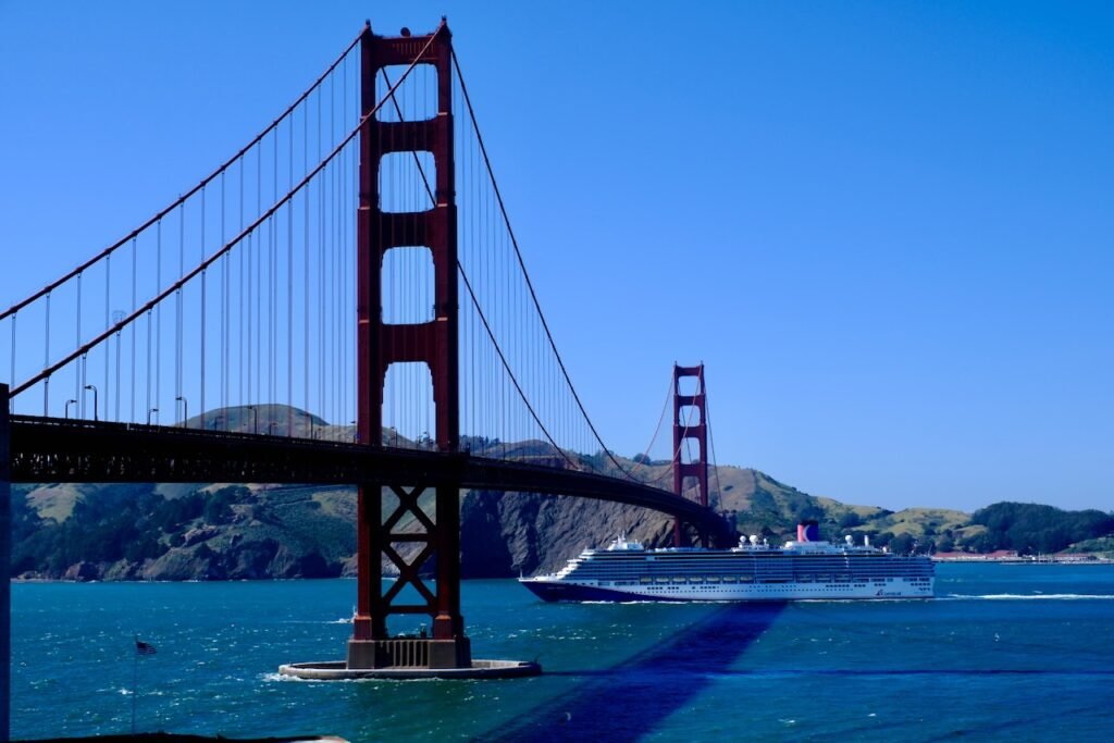 A cruise liner passes under the Golden Gate Bridge