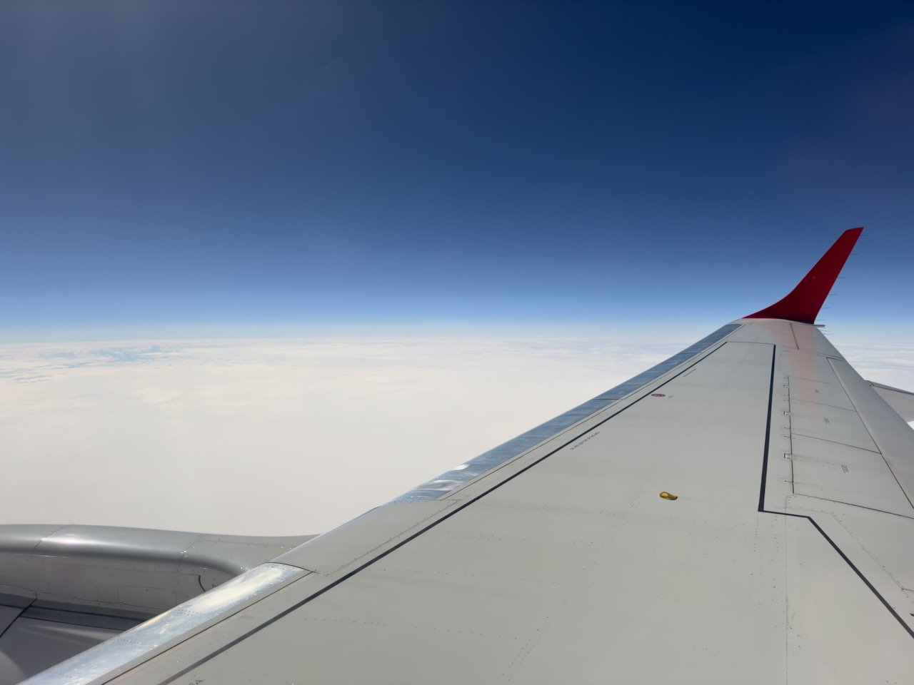 An aircraft wing above the clouds